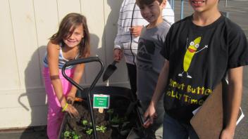 Children with a wagon of plants.