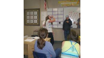 A participant imitates drinking a glass of water in a game of charades which focused on the different things our bodies need to be healthy