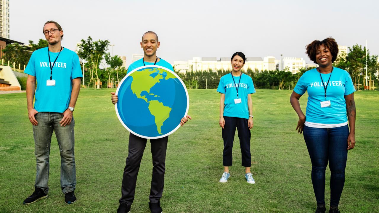 volunteers holding up an Earth poster