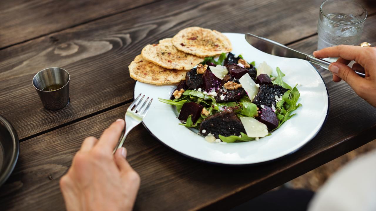a person eating a salad at a restaurant