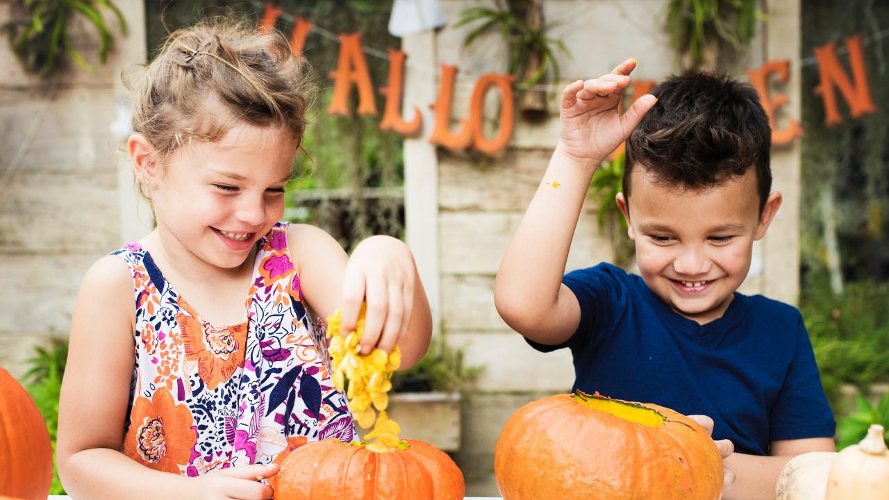 children carving pumpkins