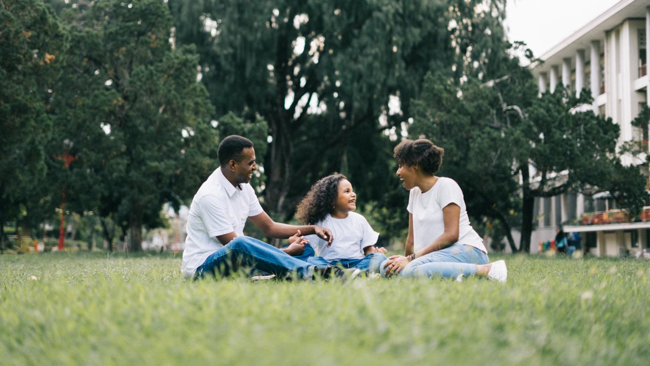 Family gathered around the grass outsided